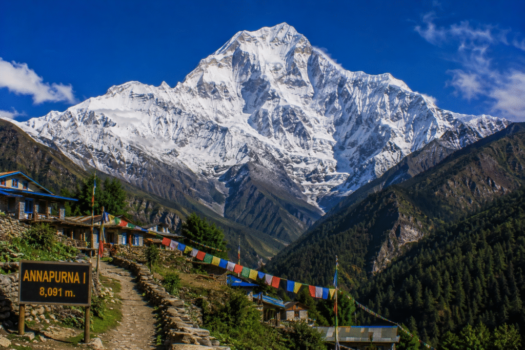 Annapurna I, the tenth-highest mountain in the world, towering above traditional Himalayan villages and lush green valleys in Nepal.