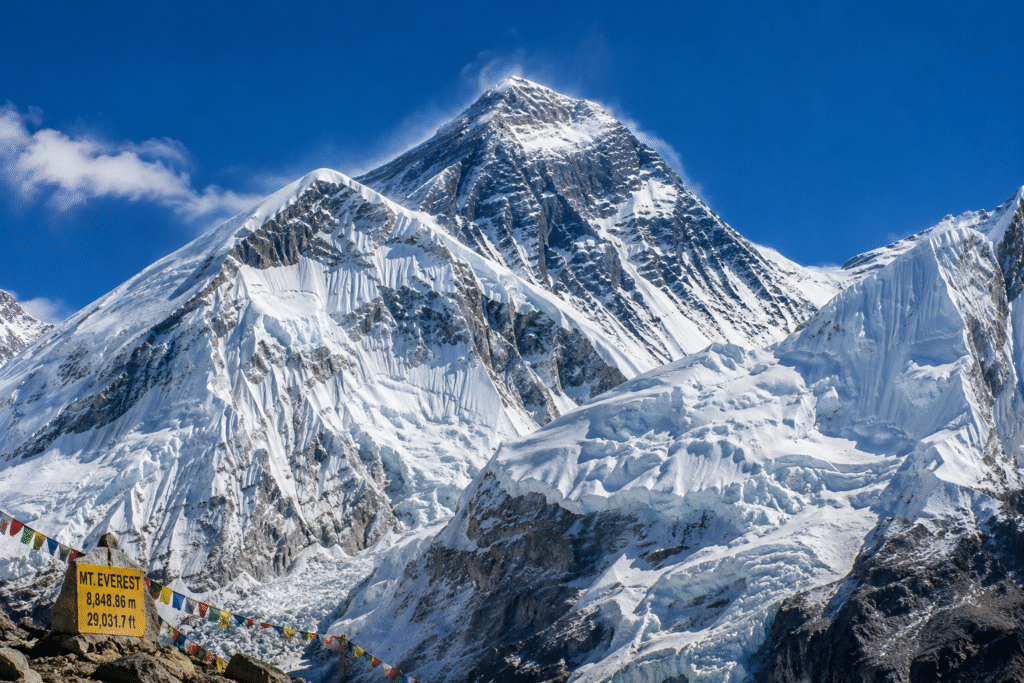 Mount Everest, the highest mountain in the world, rising above the snow-covered Himalayas under a clear blue sky.