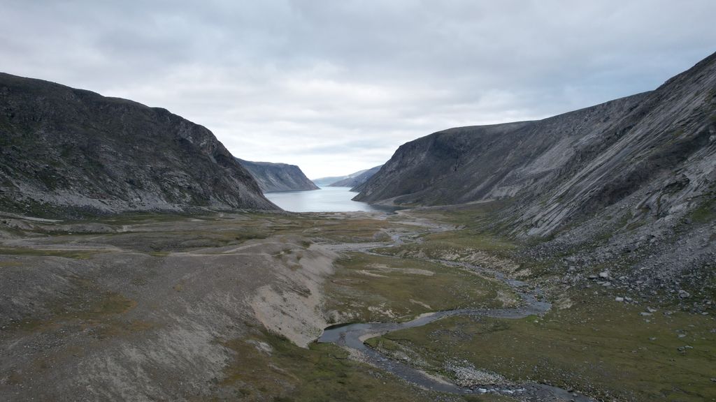 A breathtaking view of Rivière-Koksoak valley with mountains and a serene lake under a cloudy sky.